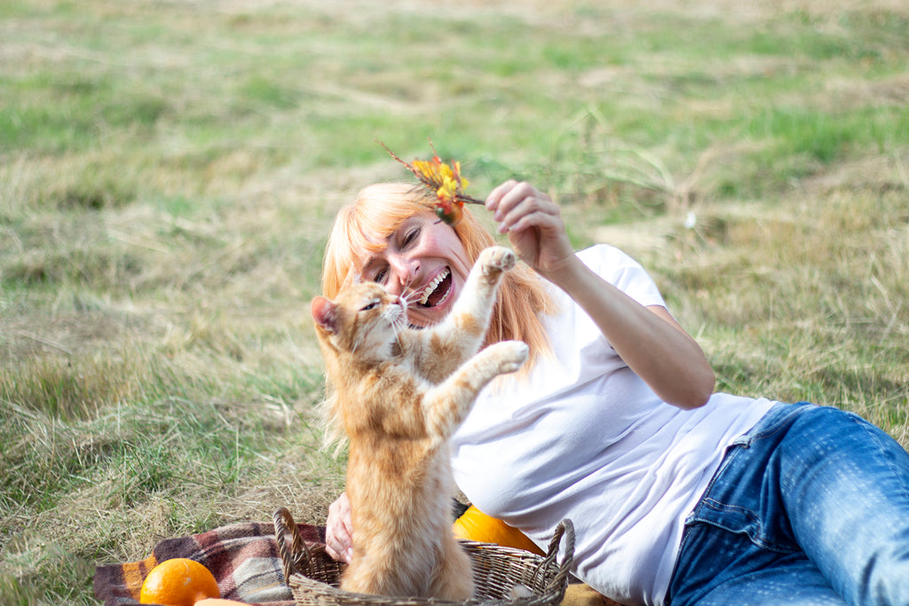 A woman playing outside with her fostered cat